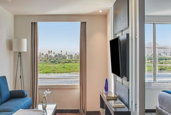 Spacious deluxe suite onboard Mövenpick MS Royal Lily Nile Cruise with Nile River view.