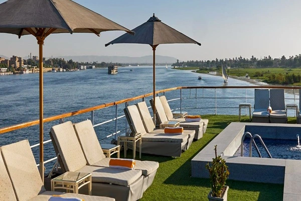 Guests relaxing on the sundeck of Mövenpick MS Royal Lily Nile Cruise with panoramic Nile River views.