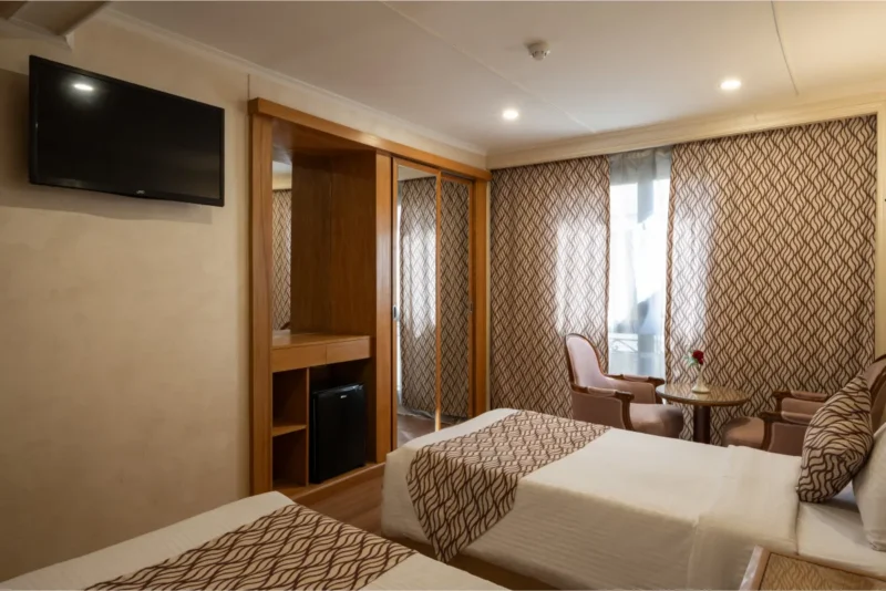 Comfortable twin cabin on M/S Kleos Nile Cruise featuring two beds, modern amenities, and panoramic Nile River views